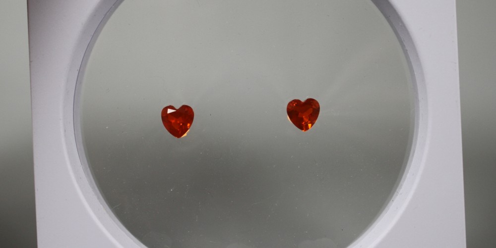 A near pair of unmounted heart shaped fire opals, each weighing approximately 0.90ct.